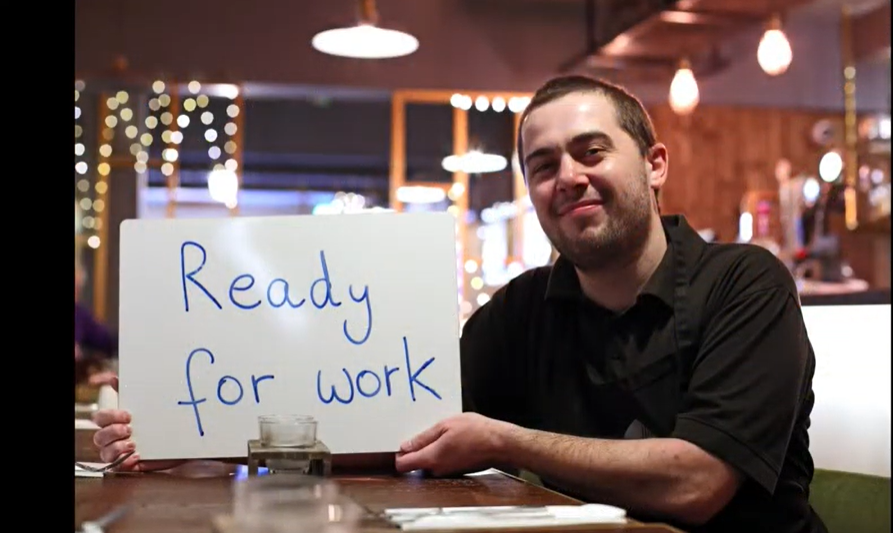 Man holding sign saying ready for work