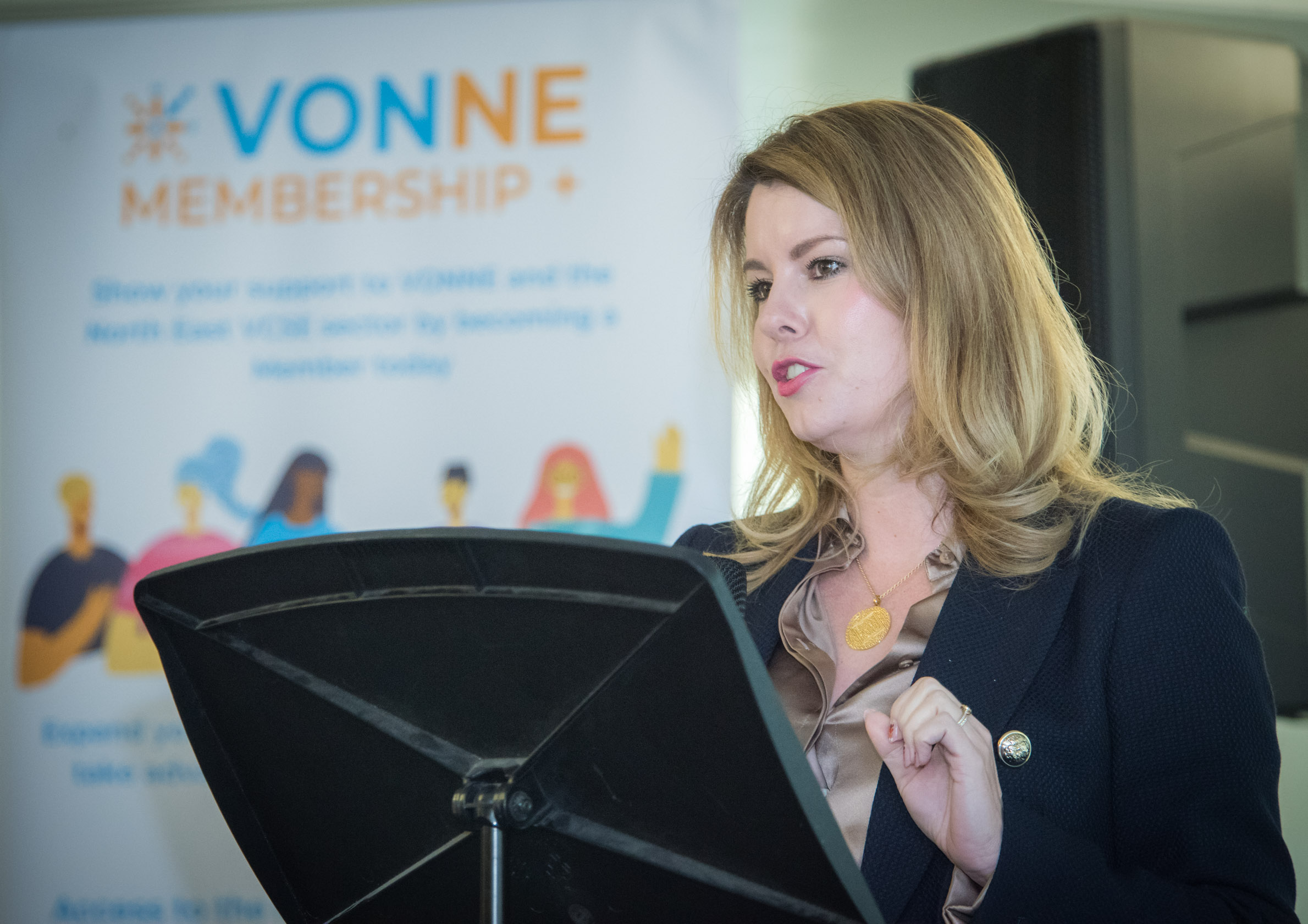 image show kim mcguinness speaking with vonne branded image in background